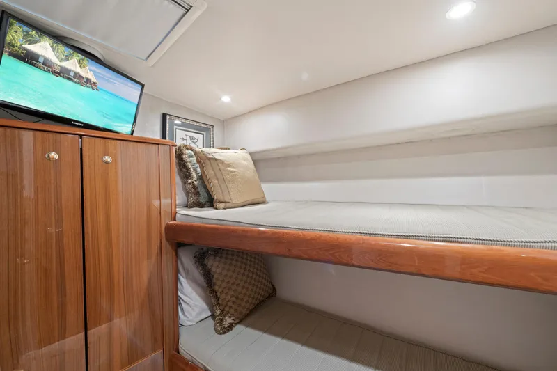 Slide: The Image of Luxurious 2005 Viking Convertible yacht cabin with cozy bunk beds and a mounted TV. - 35