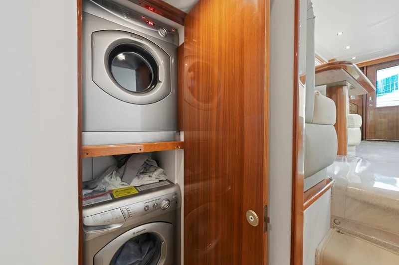 Slide: The Image of Stacked washer and dryer in 2005 Viking Convertible yacht interior with wooden cabinetry. - 37