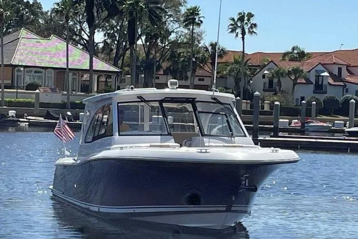 Slide: The Image of 2022 Southport 33 DC boat docked in a sunny marina setting. - 2