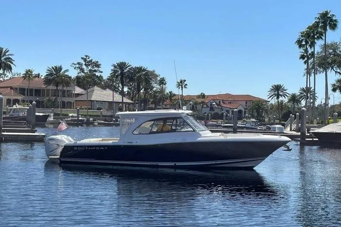 Slide: The Image of 2022 Southport 33 DC boat docked in a sunny marina with palm trees. - 3