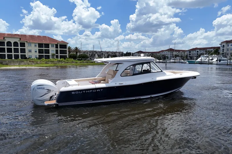 Slide: The Image of 2022 Southport 33 DC boat on water, with Yamaha engine, under a partly cloudy sky. - 15