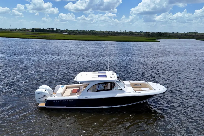 Slide: The Image of 2022 Southport 33 DC boat cruising on a scenic river under a blue sky. - 14