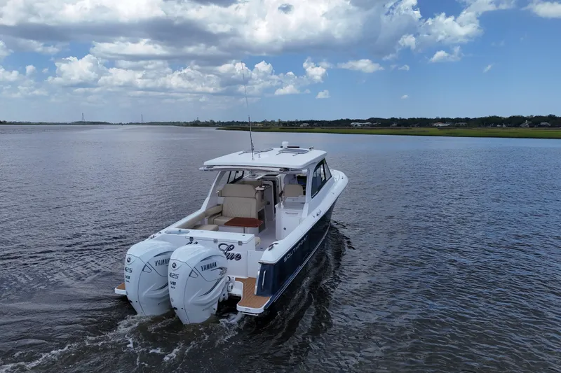 Slide: The Image of 2022 Southport 33 DC boat cruising on a calm river under a partly cloudy sky. - 27