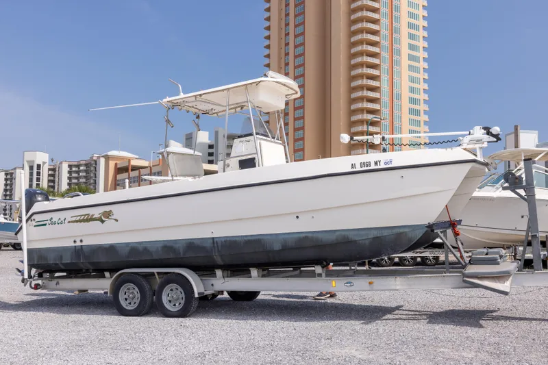 The Image of 1997 Sea Cat SL5 boat on trailer, parked near high-rise buildings. - 0