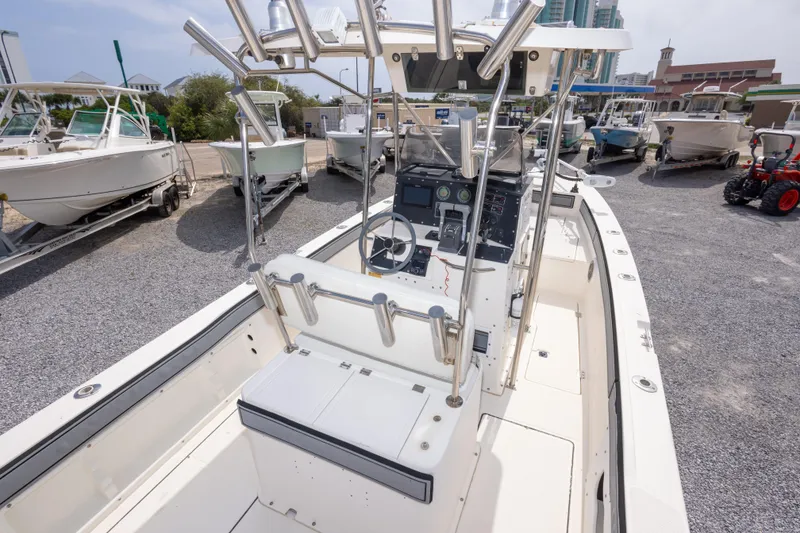 Slide: The Image of 1997 Sea Cat SL5 boat interior with steering console and seating, docked among other boats. - 18