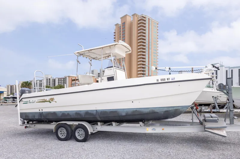 Slide: The Image of 1997 Sea Cat SL5 boat on trailer, urban backdrop, clear sky. - 2