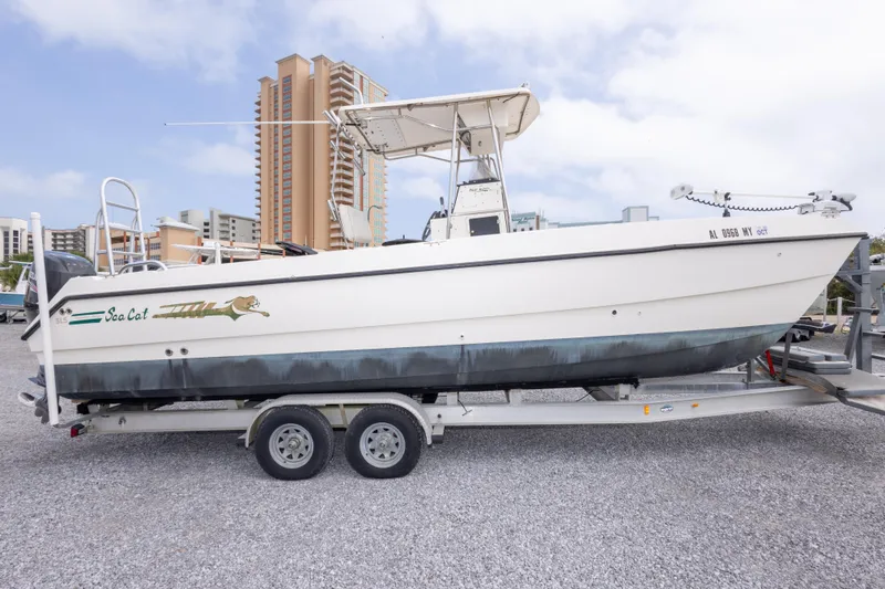 Slide: The Image of 1997 Sea Cat SL5 boat on trailer, parked with buildings in background. - 3