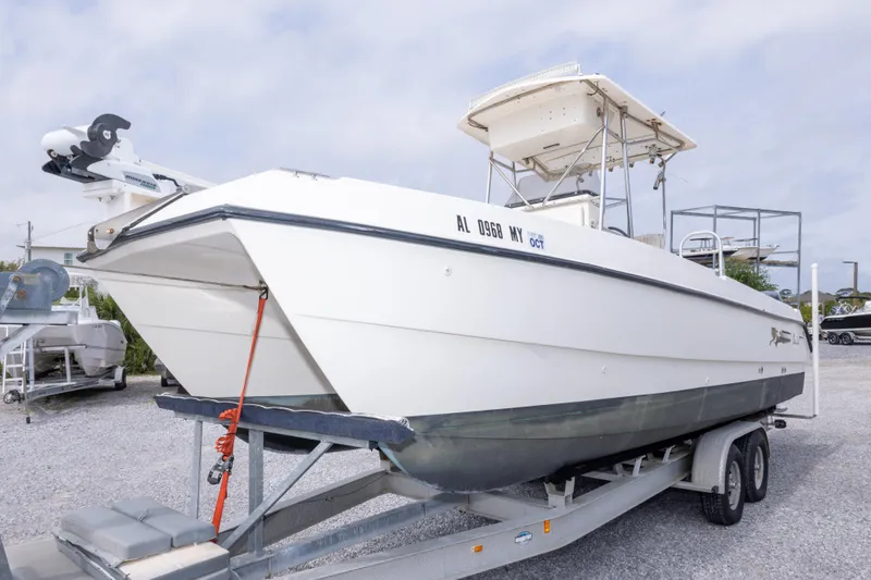 Slide: The Image of 1997 Sea Cat SL5 boat on trailer, parked outdoors under cloudy sky. - 4