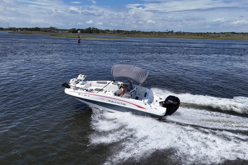 Slide: The Image of Tahoe 1950 boat cruising on a sunny day, 2022 model, with canopy and outboard motor. - 16
