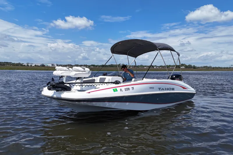 Slide: The Image of 2022 Tahoe 1950 boat on calm water under a clear blue sky. - 18