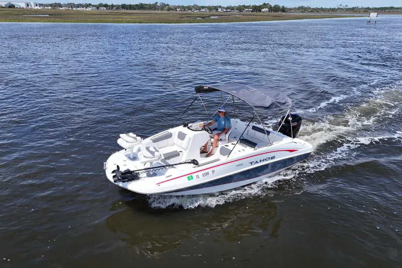 Slide: The Image of 2022 Tahoe 1950 boat cruising on a calm river with a person steering. - 20