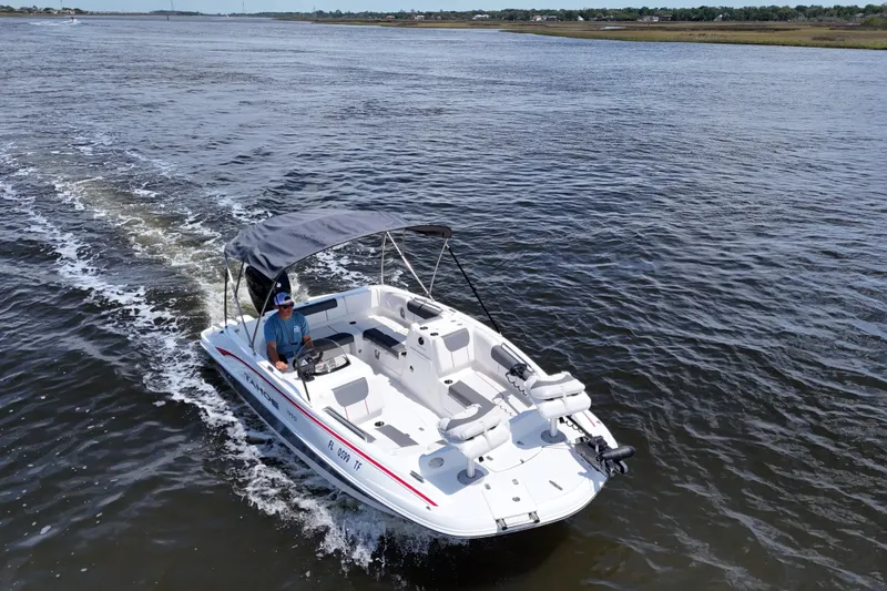Slide: The Image of 2022 Tahoe 1950 boat cruising on a calm river with a canopy and seating. - 21