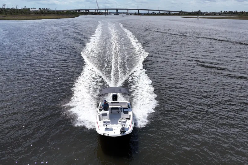Slide: The Image of A 2022 Tahoe 1950 boat cruising on a wide river with a distant bridge. - 23