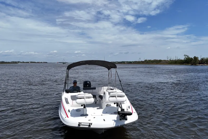 Slide: The Image of A 2022 Tahoe 1950 boat on a calm lake under a partly cloudy sky. - 5