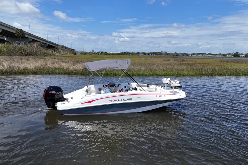 Slide: The Image of 2022 Tahoe 1950 boat cruising on a calm river under a clear blue sky. - 6
