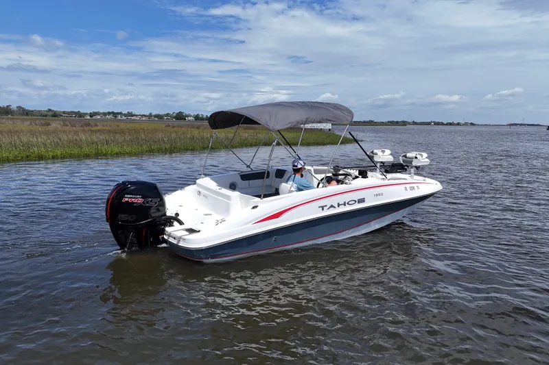 Slide: The Image of 2022 Tahoe 1950 boat cruising on a calm lake under a clear blue sky. - 9