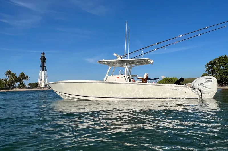 Slide: The Image of 2021 Jupiter 34 boat on water near lighthouse, clear blue sky. - 13