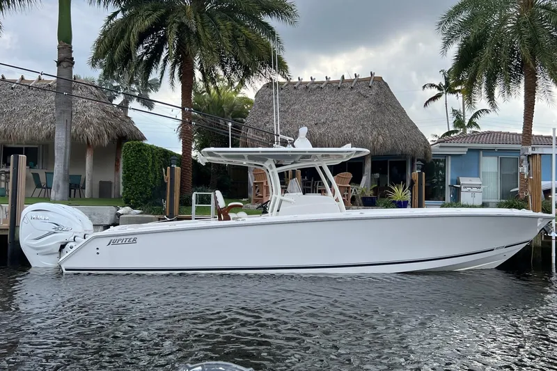 Slide: The Image of 2021 Jupiter 34 boat docked by tropical waterfront homes with palm trees. - 2