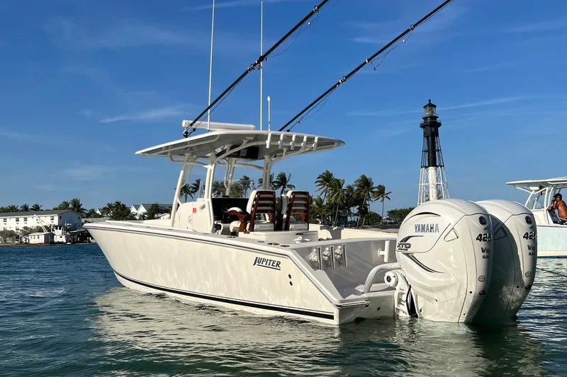 Slide: The Image of 2021 Jupiter 34 boat with Yamaha engines near a lighthouse on a sunny day. - 3
