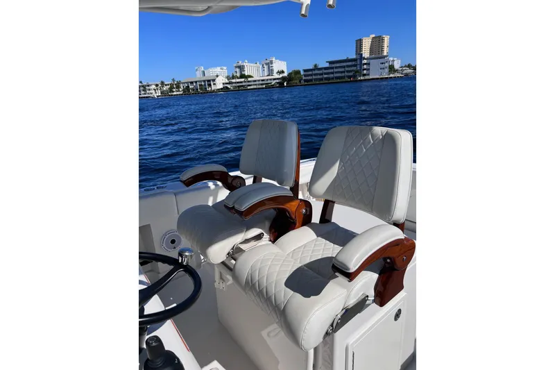 Slide: The Image of Luxurious seating on a 2021 Jupiter 34 boat with waterfront cityscape in the background. - 4