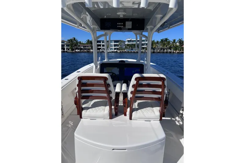 Slide: The Image of 2021 Jupiter 34 boat interior with dual helm seats, on a sunny day by the water. - 5