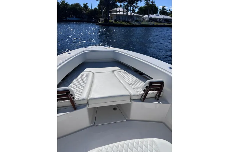 Slide: The Image of 2021 Jupiter 34 boat interior with cushioned seating on a sunny day. - 7