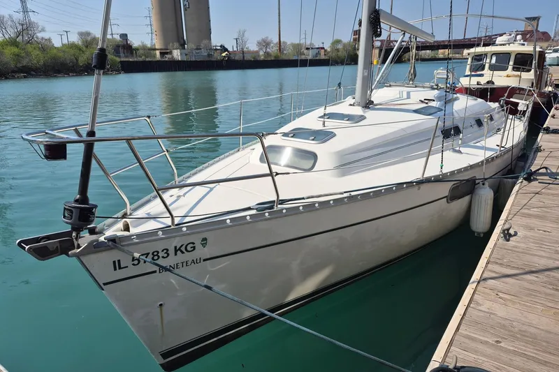 The Image of 1997 Beneteau Oceanis 321 sailboat docked in a serene marina setting. - 0