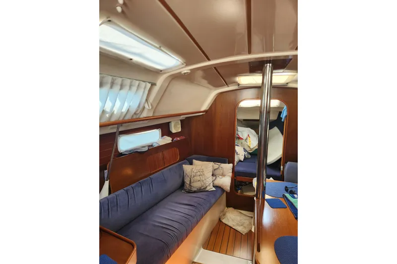 Slide: The Image of Interior of a 1997 Beneteau Oceanis 321 sailboat with cozy seating and wooden finishes. - 13