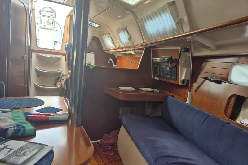 Slide: The Image of Interior of 1997 Beneteau Oceanis 321 sailboat, featuring cozy seating and navigation equipment. - 15