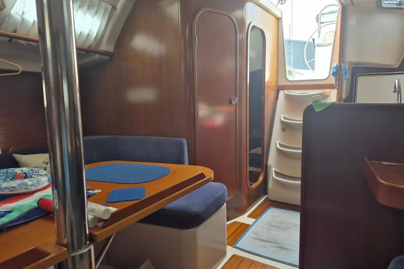 Slide: The Image of Interior of a 1997 Beneteau Oceanis 321 sailboat with cozy seating and wooden finishes. - 18