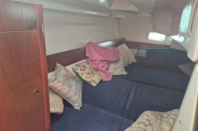 Slide: The Image of Cozy cabin interior of 1997 Beneteau Oceanis 321 sailboat with pillows and blankets. - 19