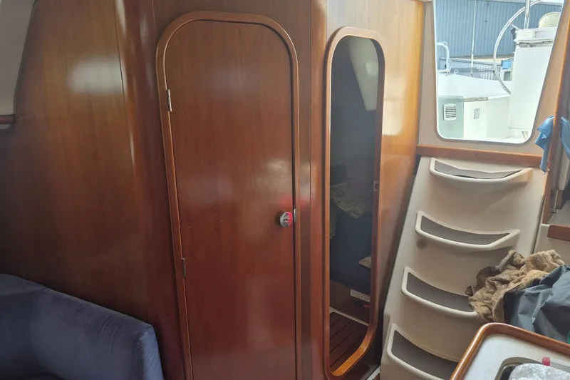 Slide: The Image of Interior of 1997 Beneteau Oceanis 321 sailboat with wooden cabinetry and steps. - 21