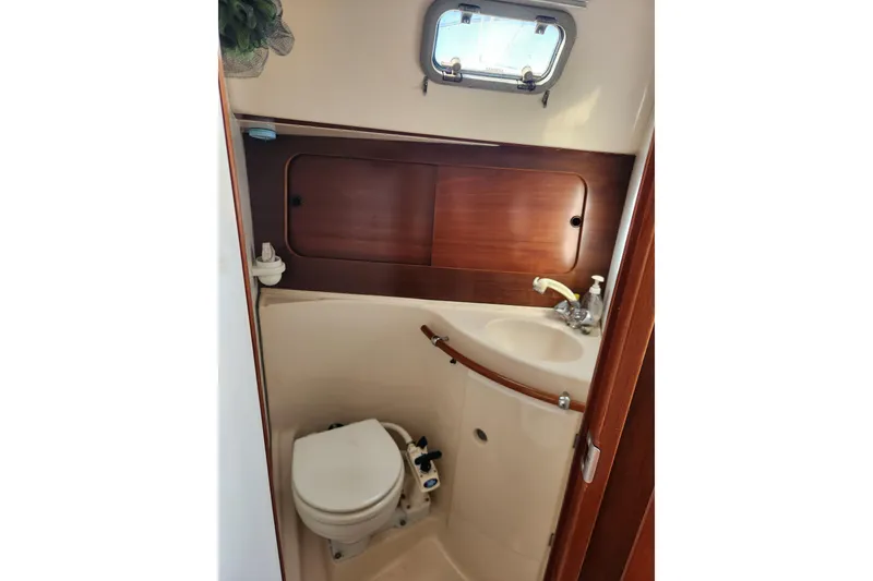 Slide: The Image of Bathroom interior of 1997 Beneteau Oceanis 321 sailboat, featuring compact toilet and sink. - 22
