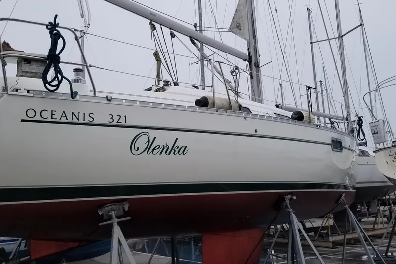 Slide: The Image of 1997 Beneteau Oceanis 321 sailboat on stands, named Olenka, in a marina setting. - 23