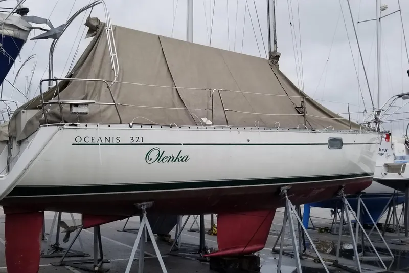 Slide: The Image of 1997 Beneteau Oceanis 321 sailboat on stands, covered, in a marina setting. - 25