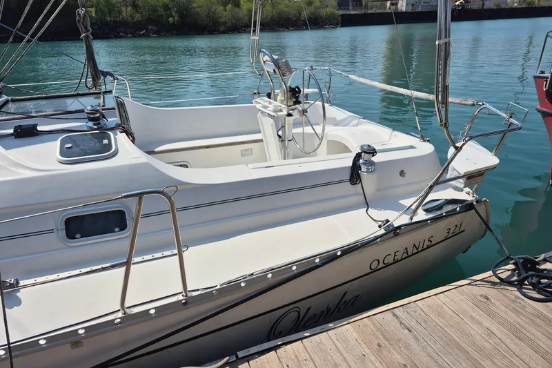 Slide: The Image of 1997 Beneteau Oceanis 321 sailboat docked on calm water, showcasing sleek design. - 6