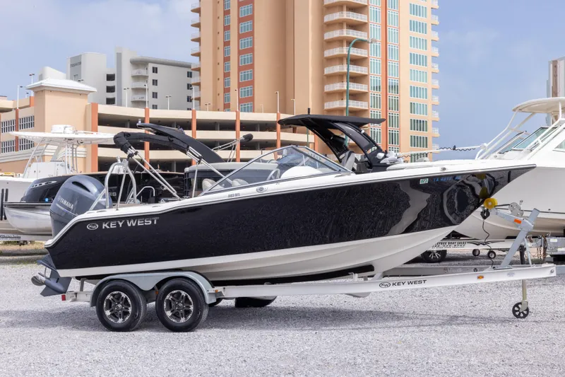 The Image of 2022 Key West 203 DFS boat on trailer, parked near modern buildings. - 0