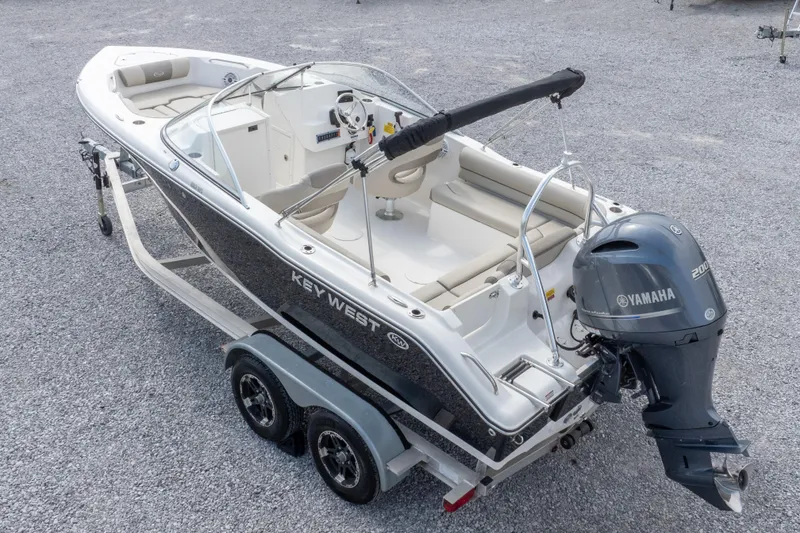 Slide: The Image of 2022 Key West 203 DFS boat with Yamaha engine on a trailer, parked on gravel. - 10
