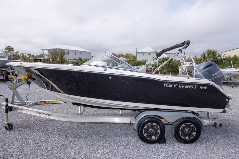 Slide: The Image of 2022 Key West 203 DFS boat on trailer, black hull, parked outdoors. - 16