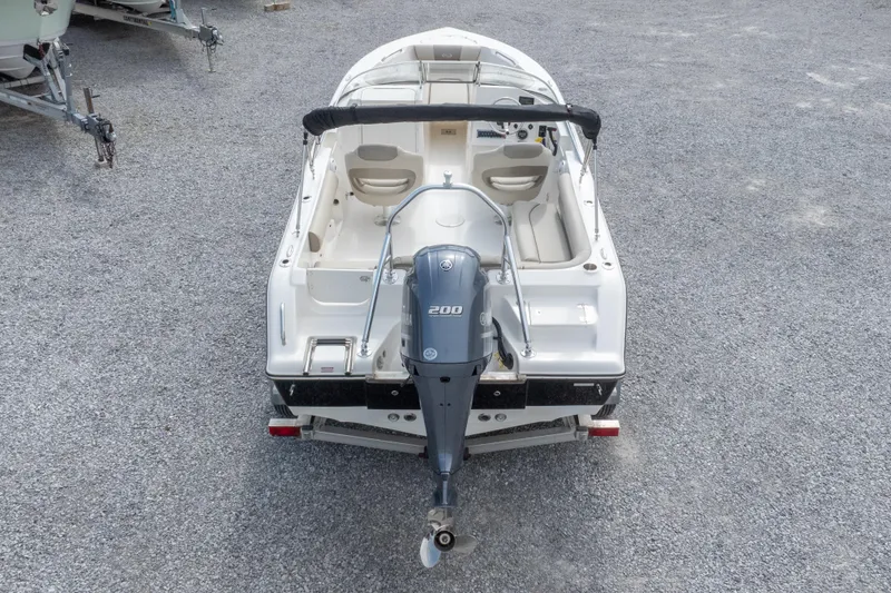 Slide: The Image of 2022 Key West 203 DFS boat with 200 HP engine, rear view on gravel surface. - 20