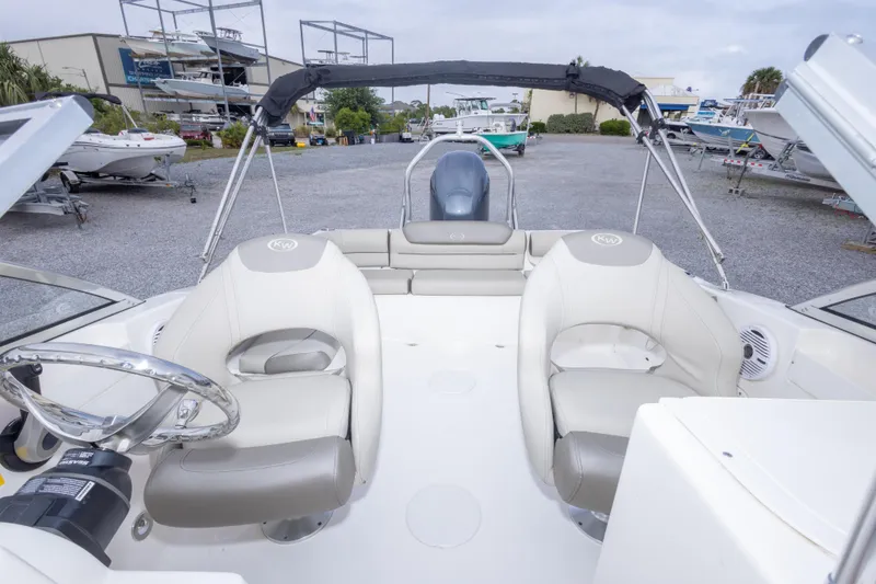 Slide: The Image of 2022 Key West 203 DFS boat interior with seating and steering wheel, displayed outdoors. - 26