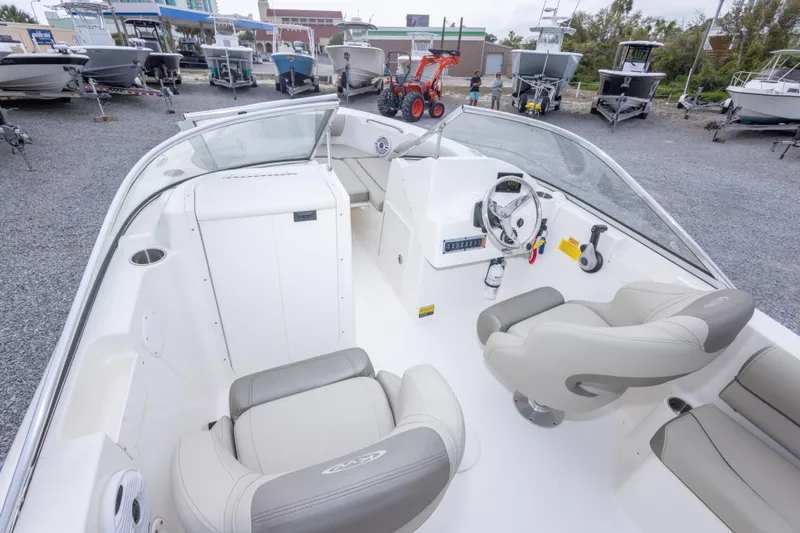 Slide: The Image of 2022 Key West 203 DFS boat interior with steering wheel and seating in a showroom. - 28