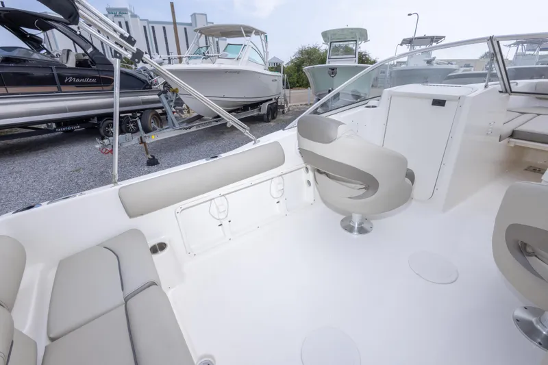 Slide: The Image of 2022 Key West 203 DFS boat interior with seating and helm, parked on gravel lot. - 35