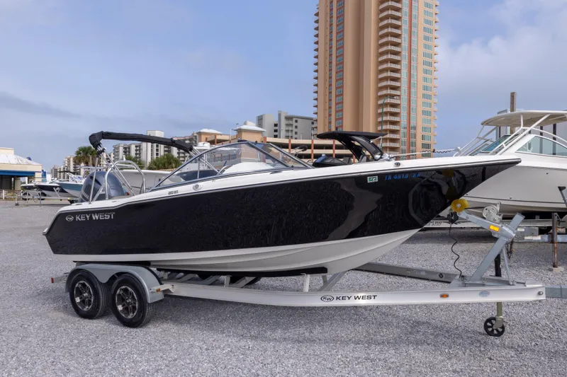 Slide: The Image of 2022 Key West 203 DFS boat on trailer, urban backdrop, clear sky. - 4