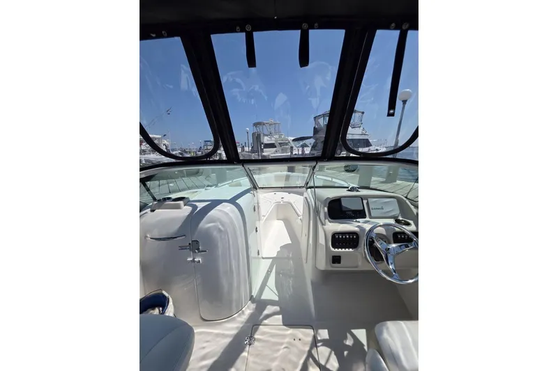 Slide: The Image of 2018 Robalo R227 Dual Console boat interior with steering wheel and dashboard view. - 2