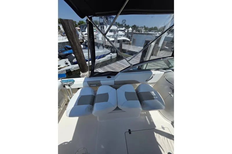 Slide: The Image of 2018 Robalo R227 Dual Console boat interior with cushioned seating at marina. - 4