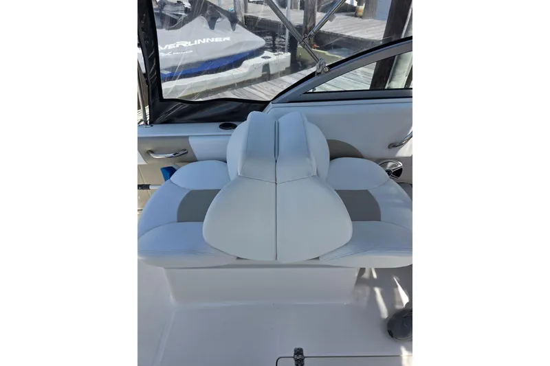Slide: The Image of 2018 Robalo R227 Dual Console boat interior with white cushioned seating. - 5