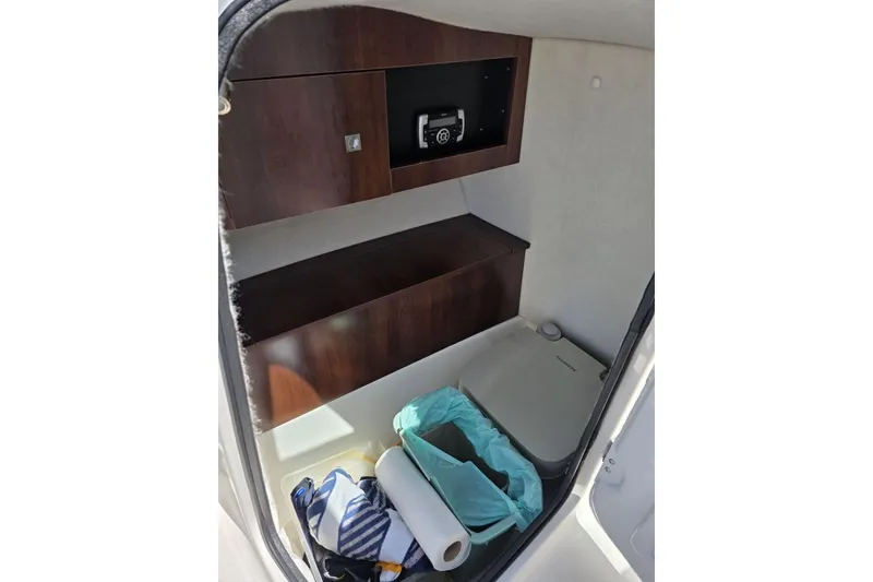 Slide: The Image of 2018 Robalo R227 Dual Console interior with storage, toilet, and essentials. - 7