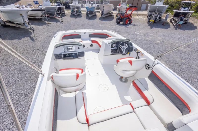 Slide: The Image of 2018 Hurricane SunDeck Sport 192 OB boat interior with white and red seating, parked outdoors. - 16
