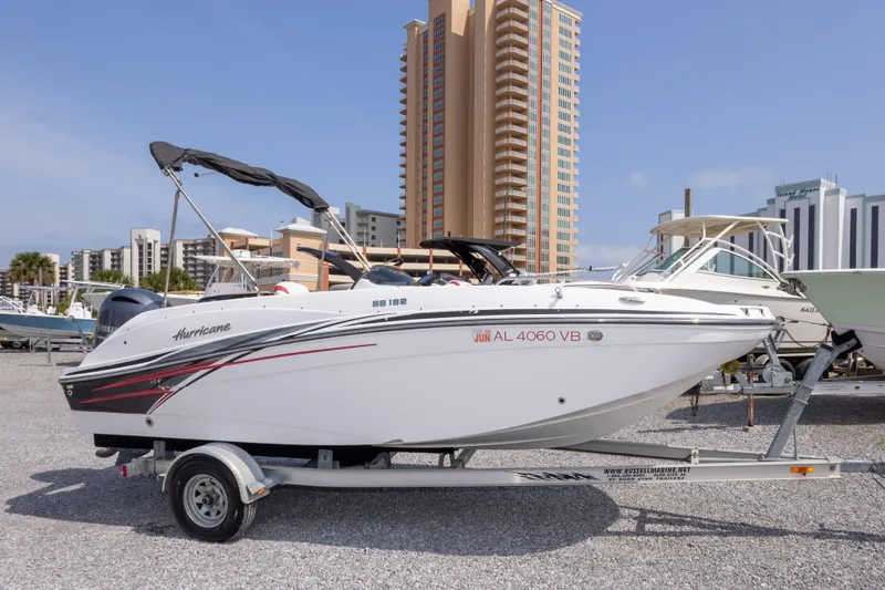 Slide: The Image of 2018 Hurricane SunDeck Sport 192 OB boat on trailer, urban backdrop, sunny day. - 3